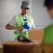 African American woman taping carboard boxes while working at distribution warehouse.